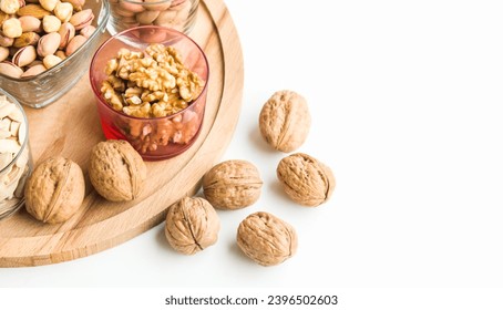 Shelled and unshelled walnuts were selected, on a wooden tray,half and above view - Shutterstock ID 2396502603