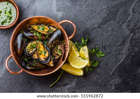 Shellfish Mussels in copper bowl with lemon and herbs. Shellfish seafood. Top view.