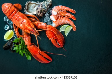 Shellfish plate of crustacean seafood with fresh lobster, mussels, shrimps, oysters as an ocean gourmet dinner background