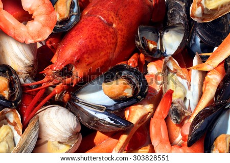 Shellfish plate of crustacean seafood as fresh lobster steamed clams mussels shrimp and crab as an ocean gourmet dinner background.