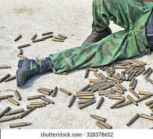 Shells of russian machine gun near soldier leg
