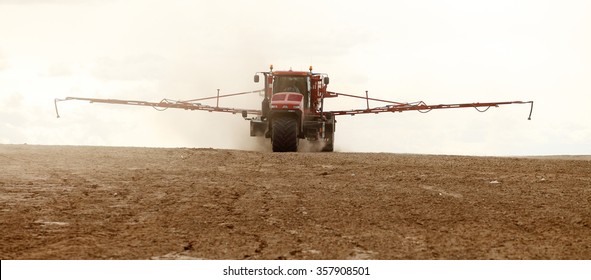 Shelly, Idaho, USA Apr. 1, 2013 A long arm fertilizer spreader putting peleted fertilizer on farm fields.