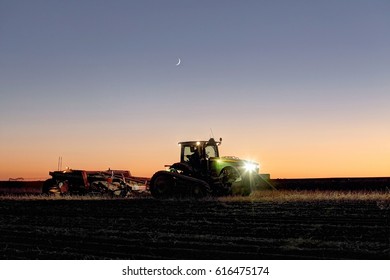 Shelly, Idaho, USA Oct. 17, 2012 A Tractor In A Farm Field At Dusk, Pulling A Potato Harvester.