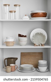 Shelves with beautiful dinnerware in kitchen