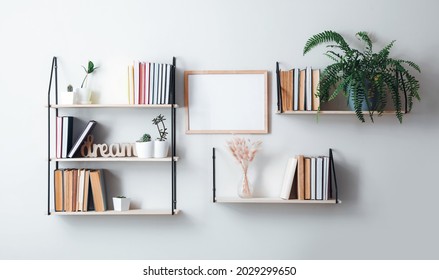 Shelves with books and decor hanging on light wall