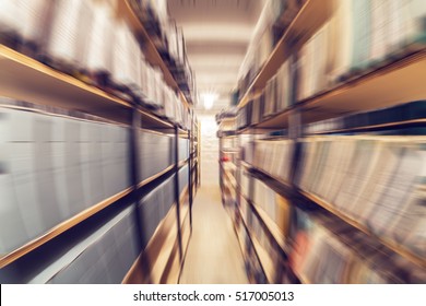 Shelves full of paper documents stored in an old archive. Radial zoom effect defocusing filter applied, with vintage instagram look. - Shutterstock ID 517005013