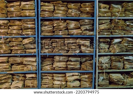 Shelves with old archival paper documents on racks in piles