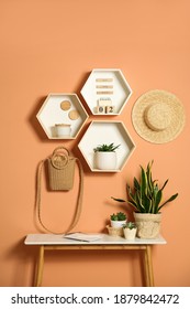 Shelves and table with decorative elements on color wall. Interior design