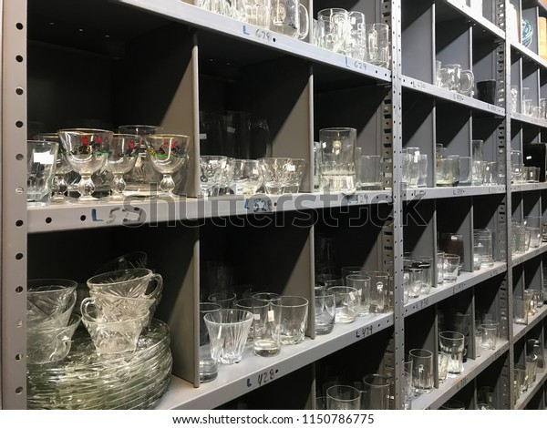 Shelves of used clear glassware dishes for sale on\
shelf in thrift shop\
store