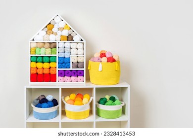 Shelving with storage baskets and colored balls of yarn for knitting. Bright yarn balls lined up on the shelves. Organizing and storage in craft room. Handmade, needle craft, creativity and  hobby.  - Powered by Shutterstock