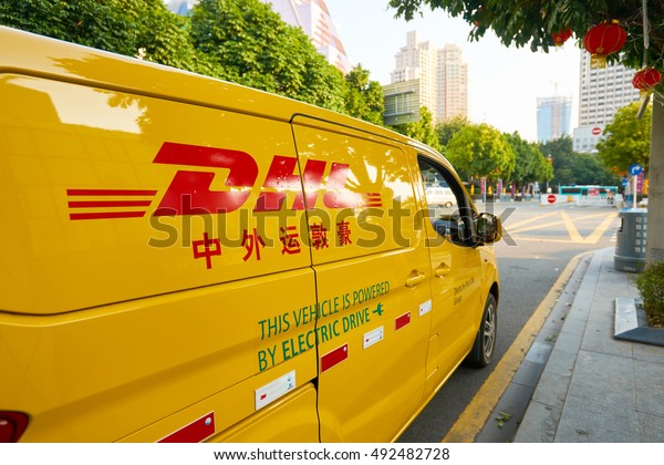 SHENZHEN,\
CHINA - FEBRUARY 05, 2016: a DHL car in the street. DHL Express is\
a division of the German logistics company Deutsche Post DHL\
providing international express mail\
services.