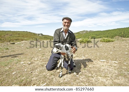Shepherd with one of his goats in the countryside from Portugal