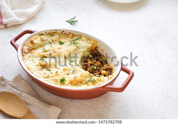 Shepherd\'s Pie with ground beef, potato and cheese\
on white background, top view, copy space. Traditional homemade\
casserole - Shepherds\
Pie.