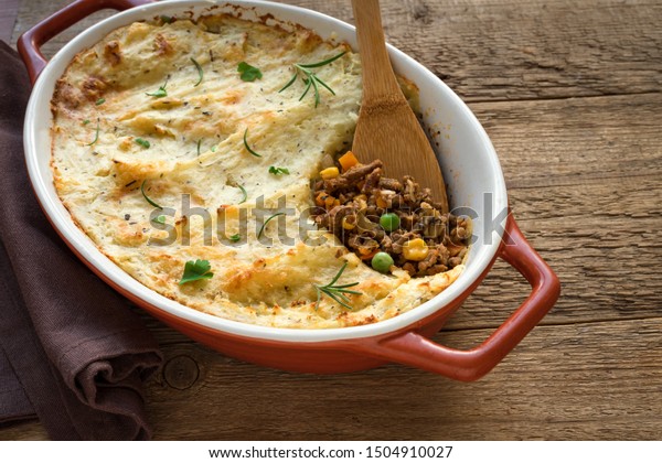 Shepherd\'s Pie with ground beef, potato and cheese\
on wooden background, top view, copy space. Traditional homemade\
casserole - Shepherds\
Pie.