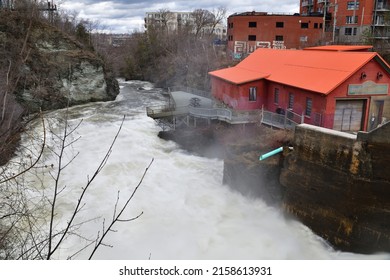 SHERBROOKE, QUEBEC, CANADA - April 16, 2022: Magog River Rushing Water Frontenac Hydroelectric Power Plant Early Spring