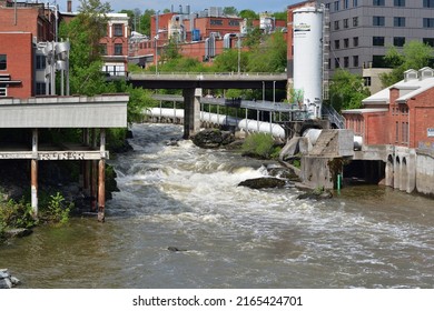 SHERBROOKE, QUEBEC, CANADA - MAY 6, 2022 - Magog River Sherbrooke Abenakis Hydroelectric Power Plant. Large White Pentock And Footbridge.