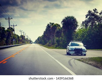 Sheriff Car In Florida Everglades Parked On The Edge Of The Road On A Cloudy Day, USA