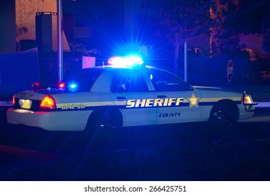 Sheriff cruiser car with his lights on at night on a call to protect the peace