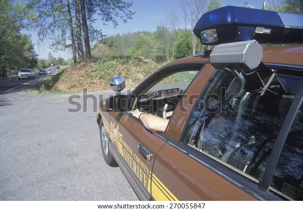 Sheriff sitting in car at speed trap, Greene\
County, Virginia