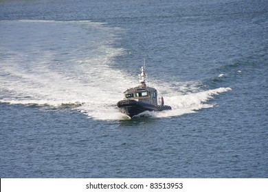 A Sheriff's Cruiser Cutting Through The Water In A Blue Bay