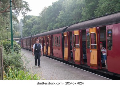 Sheringham, Norfolk, UK - SEPTEMBER 14 2019: Train Conductor Walks The Platform Next To A Red Vintage Passenger Carriage