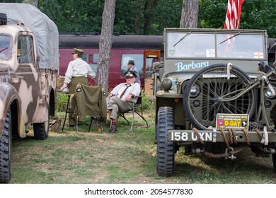 Sheringham, Norfolk, UK - SEPTEMBER 14 2019: Man In Military Officer Uniform Rests On Chair Drinking Coca Cola