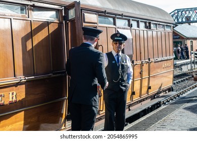 Sheringham, Norfolk, UK - SEPTEMBER 14 2019: Men In Vintage Train Conductor Uniforms Stands By A Vintage Passenger Carriage During 1940s Weekend