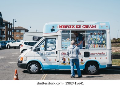 Sheringham, UK - April 21, 2019: Man buying ice-cream from an ice-cream truck in Sheringham, an English seaside town within the county of Norfolk, UK.