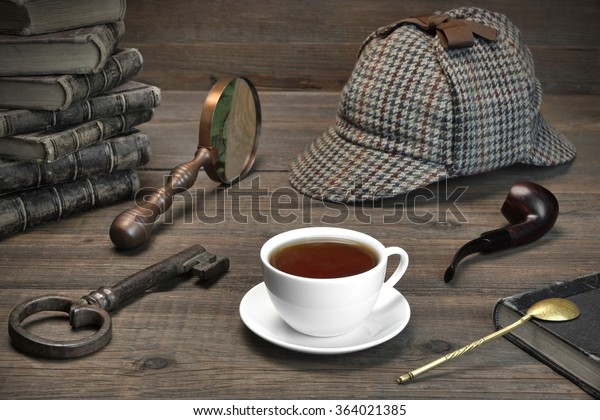 Sherlock Concept. Private Detective Tools On The Wood Table Background. Deerstalker Cap,  Magnifier, Key, Cup, Notebook, Smoking Pipe.Overhead View
