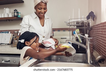 Shes Always So Helpful. Cropped Shot Of An Adorable Little Girl Helping Her Mother Do The Dishes At Home.