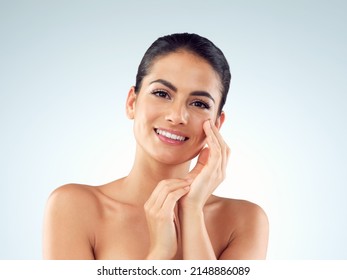Shes been gifted with a gorgeous glowy complexion. Studio shot of an beautiful young woman feeling her skin against a gray background. - Shutterstock ID 2148886089