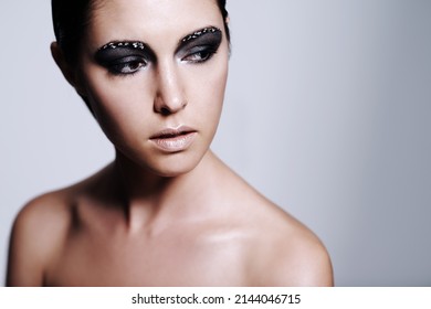 Shes Got An Edgy Beauty. Studio Shot Of A Beautiful Young Woman Wearing Metallic-colored Makeup.