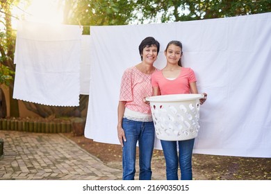 Shes Helping Mom With The Chores. Portrait Of A Mother And Daughter Hanging Up Laundry Together Outside.