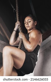 Shes A Long Way Up. Cropped Shot Of A Young Woman Climbing A Rope At The Gym.