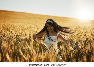 Shes Mother Natures Favourite Child. Shot Of A Cute Little Girl Twirling In A Cornfield.