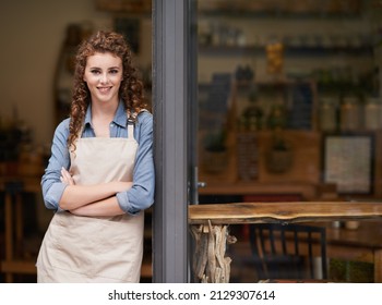 Shes proud of her little shop. A young woman standing in her store doorway. - Powered by Shutterstock