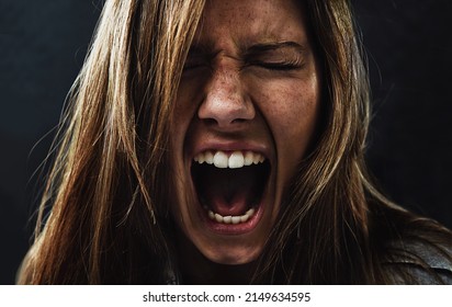 Shes reached the end of her rope. A young woman screaming uncontrollably while isolated on a black background. - Shutterstock ID 2149634595
