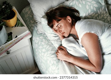 Shes stuck in la la land. High angle shot of an attractive young woman sleeping in her bed at home. - Powered by Shutterstock