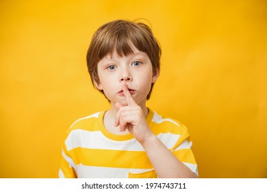 Shh, Keep Silence Concept. Young Caucasian Child Boy Gesturing, Hush Sign Posting Standing Isolated Over Yellow Background. Studio Shot. Finger On Lips, Silent Gesture, Secret. Copy Space