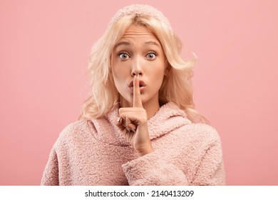 Shh, Keep Silence. Young Woman Showing Secrecy Gesture, Gesturing Hush On Pink Studio Background. Confidential Information Concept