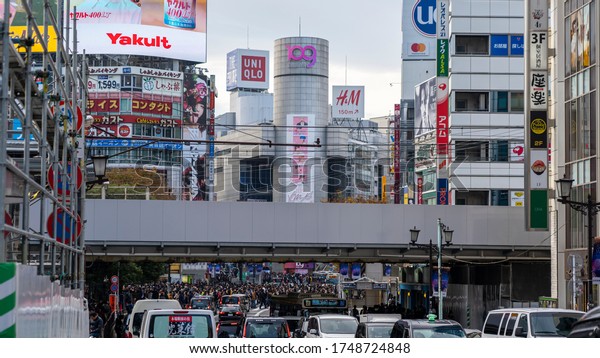 SHIBUYA, TOKYO, JAPAN - December 1st,\
2019: Afternoon view of the buildings, traffic and crowded busy\
streets of Tokyo, near the area of Shibuya crossing\
scramble.