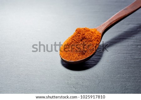 Shichimi pepper in Wooden spoon on black plate,