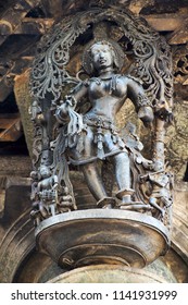 Shilabalika, Celestial Maiden, In A Beauty Dance Pose. A Lady Practicing Dance Steps. Her Maids Are Playing Their Musical Instruments . Chennakeshava Temple, Belur, Karnataka, India. 