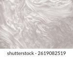 Shimmering silver abstract background. Liquid glitter paint texture waves and swirls. Beautiful shiny white glitter texture. Metallic silver paint close-up as a holiday background.