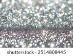 A shimmering silver glitter background, with sparkling reflections that create a dazzling, festive atmosphere