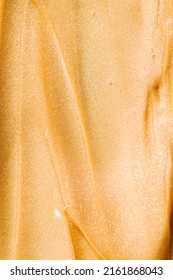 A Shimmery Gold Thick Liquid Texture. This Is A Skin Or Body Mask. 