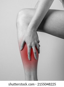 Shin Pain. Woman Holding Leg With Red Spot. Tendons, Muscles Inflammation, Injury, Bone Bruise Consequences. Black And White. High Quality Photo