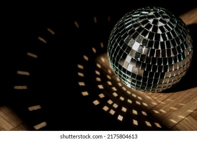 Shining disco ball isolated on wooden floor, shadow tin, bright highlights in shadow from disco ball, fun party concept - Powered by Shutterstock