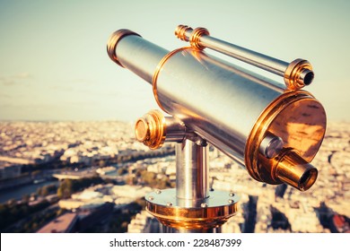 Shining metal telescope mounted on the railings of Eiffel Tower, Paris. Retro stylized vintage tonal correction filter with Instagramm effect - Powered by Shutterstock