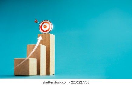 Shining rise up arrow shoot up towards the goal, 3d target icon on the top of wooden cube blocks, bar graph chart steps, business growth process, technology trend, economic improvement concepts.